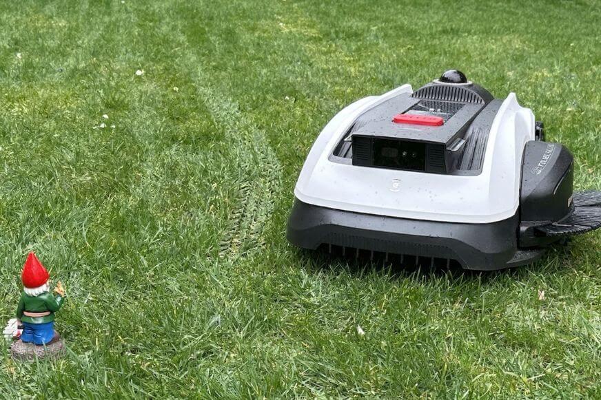 ECOVACS GOAT O1200 LiDAR PRO weicht einem kleinen Gartenzwerg auf dem Rasen aus
